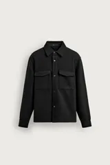 Sobrecamisa regular fit de color negro, confeccionada en tejido de sarga con estructura diagonal repelente al agua. Cuenta con cuello solapa, manga larga con puños abotonados, dos bolsillos con solapa en el pecho y cierre frontal con botones.
