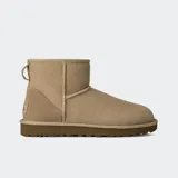 Botas UGG modelo Classic Mini II, de caña baja, color tostado, elaboradas en piel de oveja con costuras visibles y suela gruesa marrón.