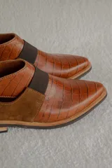 Bota corta color borgoña con textura de reptil, puntera fina, elástico negro en el empeine y talón descubierto.