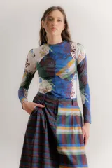 Falda midi de corte recto confeccionada en popelina de algodón, con diseño estampado floral en tonos azules y rojizos sobre fondo azul oscuro. Presenta un diseño con pinzas en la cintura y cierre frontal.