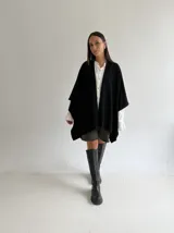 Ruana de tejido de punto trenzado en color crudo, con diseño abierto, corte holgado y mangas amplias tipo kimono.