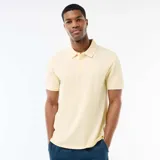 Remera tipo polo de color amarillo claro, con cuello clásico y detalles en blanco en el borde del cuello y las mangas. Presenta cierre frontal de botones y mangas cortas.