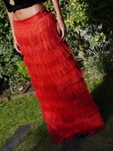 Falda larga de lino color beige con volados de rafia en capas, tajos laterales y cintura elástica en la parte posterior.