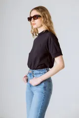 Camiseta básica de algodón orgánico color negro, con cuello redondo alto y mangas cortas con doblez. Incluye un pequeño bordado tono sobre tono de la marca en el pecho.