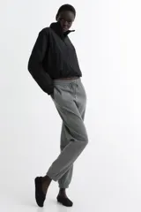 Pantalón deportivo de tiro alto confeccionado en felpa de mezcla de algodón con interior cepillado. Presenta cintura elástica con cordón de ajuste, bolsillos laterales al bies y puños elásticos en los bajos.