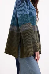 Sweater de punto con diseño de rayas horizontales en degradé de tonos azules y verdes. Presenta cuello redondo, corte holgado y mangas amplias con tajos laterales.