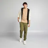 Pantalón tipo cargo color verde militar, con bolsillos laterales con solapa, corte ajustado y puños elásticos en los tobillos.