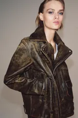 Chaqueta tipo biker de cuero con efecto desgastado, cuello de solapa, cierre frontal con cremallera metálica, bolsillos delanteros con cremallera y bolsillo pequeño con solapa, mangas largas con cremalleras en los puños y bajo con trabillas.