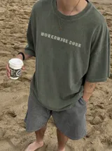 Remera oversize gris con efecto acid wash y estampa frontal con la leyenda "WORLDWIDE TOUR" en tipografía gótica.