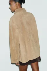 Chaqueta de ante color tostado con cuello solapa, manga larga con puño, bolsillos con solapa en el delantero y cierre frontal con botones.