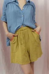 Short blanco de calce relajado con cintura elástica y lazo regulable. Presenta bolsillos amplios con ribete interior de color naranja neón.