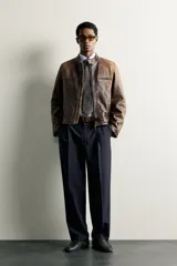 Pantalón relaxed fit azul marino confeccionado en tejido con lana, con bolsillos frontales, bolsillos traseros de doble vivo y pliegues en la parte delantera.