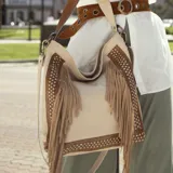 Bolso tipo morral color beige con detalles en tabaco, confeccionado en cuero vacuno. Tiene cierre en la tapa trasera, interior forrado con bolsillo con cierre y bolsillo para el móvil. Incluye manija corta y correa extensible removible.