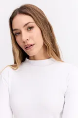 Polera de manga larga con cuello alto, confeccionada en tejido de algodón con textura acanalada y calce ajustado al cuerpo.