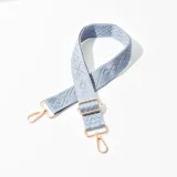 Correa celeste para cartera con diseño geométrico y herrajes metálicos color cobre.