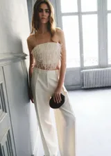 Top de diseño strapless color blanco marfil, con textura de flecos tipo plumas en todo el cuerpo y corte crop.