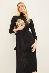 Falda midi plisada de color negro, con cintura elástica para un ajuste cómodo.