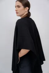 Ruana negra de tejido de punto grueso, confeccionada en 100% baby alpaca.
