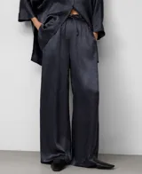 Pantalón ancho de pierna recta, color gris oscuro, confeccionado en acetato con textura arrugada y brillo satinado. Posee cintura elástica ajustable con cordón y bolsillos traseros.