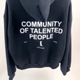 Canguro negro de algodón con capucha y corte boxy. Estampado en la espalda con la frase "Community of talented people" y el logo de la marca.