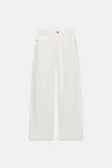 Jeans de mezclilla en color negro gastado, tiro alto, diseño de cinco bolsillos y corte de pierna ancha extra larga. Cuenta con cierre frontal de cremallera y botón metálico.