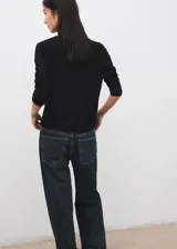 Jersey Luccac negro de cuello alto y manga larga, de corte recto y diseño clásico.