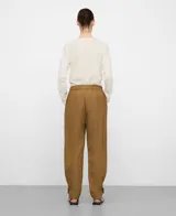 Pantalón de visco-poliamida color verde, efecto arrugado, con bolsillos frontales, costuras cargadas, cintura elástica en la espalda y bajo ajustable con trabilla y botón.
