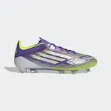 Championes de fútbol Adidas F50 Elite para terreno firme, con exterior en tonos morado iridiscente y verde lima, tres franjas plateadas y cordones morados. Poseen suela con tapones transparentes.