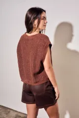 Chaleco oversize de punto texturado color rosa, con escote redondo y mangas sisa caídas.