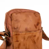 Bolso bandolera pequeño de cuero color terracota, ideal para llevar el celular, tarjetas y maquillaje. Cuenta con cierre superior, bolsillo interno, bolsillo externo y correa ajustable. Hecho a mano en Uruguay.