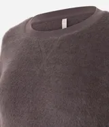 Blusa de pijama manga larga confeccionada en tejido fleece de tacto suave y aspecto peludo. Presenta cuello redondo, puños y ruedo acanalados.