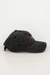 Gorro tipo gorra bordó con efecto gastado, visera curva y diseño de seis paneles con ojales de ventilación bordados. Presenta un bordado frontal minimalista en fucsia que representa un sol sobre el horizonte y detalles de texto bordados en el lateral.