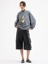 Buzo de algodón color gris con calce holgado, cuello redondo y mangas largas. Presenta un estampado frontal de cerezas con llamas y logo bordado en la espalda.