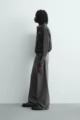 Camisa de corte relajado en color negro con rayas verticales finas. Presenta un diseño estilo western con vivos blancos en contraste en el canesú, cuello, tapeta frontal y puños. Cuenta con cuello solapa, cierre frontal de botones y mangas largas.
