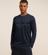 Remera deportiva de manga larga con cuello redondo, confeccionada en tejido de malla de poliéster. Presenta un diseño con estampado geométrico tipo delta punteado en el pecho.