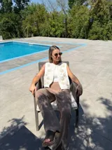 Chaleco marrón con bordados florales en color crema en los bordes y el frente. Presenta un diseño sin mangas con escote en V.