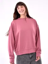 Buzo de corte holgado color rosa viejo, con cuello redondo y mangas largas.