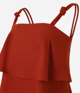 Blusa femenina color azul marino, sin mangas, con breteles anchos que tienen nudos decorativos y escote recto. Presenta capas sobrepuestas en la parte delantera que crean un leve volumen.