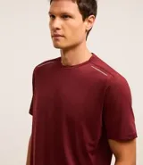 Remera deportiva masculina de manga corta con cuello redondo, confeccionada en tejido técnico con tecnología Dry para mayor transpirabilidad. Presenta detalles reflectantes en los hombros y un diseño liso en color verde melange.