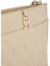 Cartera bandolera color beige con diseño acolchado de rombos y correa ajustable. Cuenta con el logo de Tommy Hilfiger en la parte delantera.