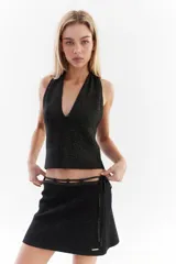 Top bordó de punto con lurex, escote en V profundo estilo halter y diseño sin mangas.