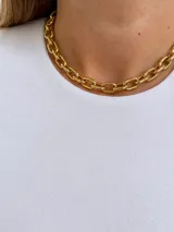 Gargantilla de cadena gruesa de eslabones dorados, con diseño corto y acabado brillante.