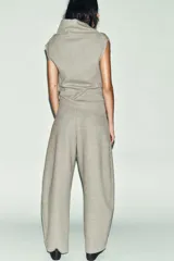 Pantalón de tiro alto con diseño cruzado frontal y cierre de botón. Presenta pierna ancha y cintura elástica, confeccionado en tejido de algodón.