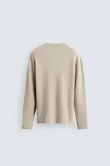 Jersey relaxed fit de punto acanalado color marrón oscuro, con cuello redondo tipo panadera y cierre frontal de tres botones. Tiene manga larga y efecto lavado.