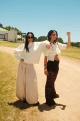 Pantalón ancho de tiro alto color beige claro, con cintura ajustable mediante cordón.