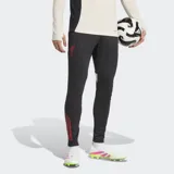 Pantalón de entrenamiento de fútbol Adidas Liverpool FC Tiro 25 Competition, color negro, corte ajustado (slim fit) con puños elásticos y tres franjas verticales rojas en la parte inferior de la pierna. Incluye el escudo del Liverpool FC aplicado con calor en el muslo.