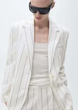 Blazer de corte recto con estampado de rayas verticales, cuello con solapas de muesca, hombros estructurados y cierre frontal con botones. Cuenta con bolsillo de ribete en el pecho y dos bolsillos con solapa en la parte frontal.