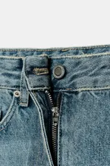 Jeans de tiro medio con corte balloon leg y largo al tobillo. Presenta diseño de cinco bolsillos, cintura con trabillas y cierre frontal con cremallera y botón metálico.