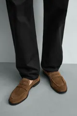 Mocasín casual fabricado en piel con acabado de serraje, con detalle de bordón y antifaz en el empeine, horma redonda y suela a contraste.