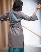 Túnica beige de gabardina de lana estampada con diseño abstracto en tonos ocre. Cuenta con cuello mao, bolsillos laterales y dos piezas a modo de bufandas que se pueden anudar de diferentes maneras.